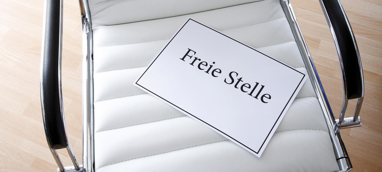 Weißer Bürostuhl mit Schriftzug 'Freie Stelle'