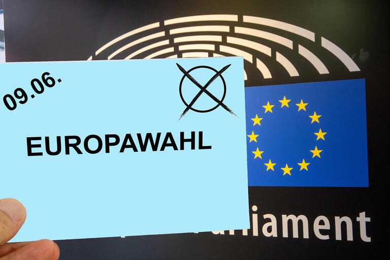 Symbolischer Umschlag vor dem Schriftzug und Wappen des EU-Parlamentes in Straßburg (Composing) zur Eurpawahl am 09.06.2024