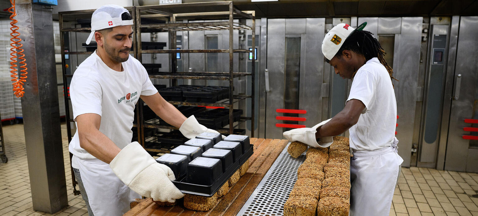 Mitarbeiter der Bio-Bäckerei Beumer & Lutum stellen in der Backstube in Neukölln frisch gebackenes Brot für den Transport zu den Kunden bereit. 